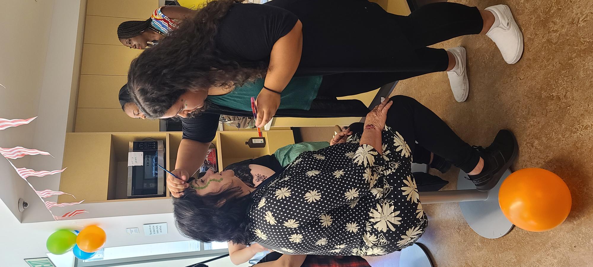 King Hall staff getting their faces painted at the Carnival. 