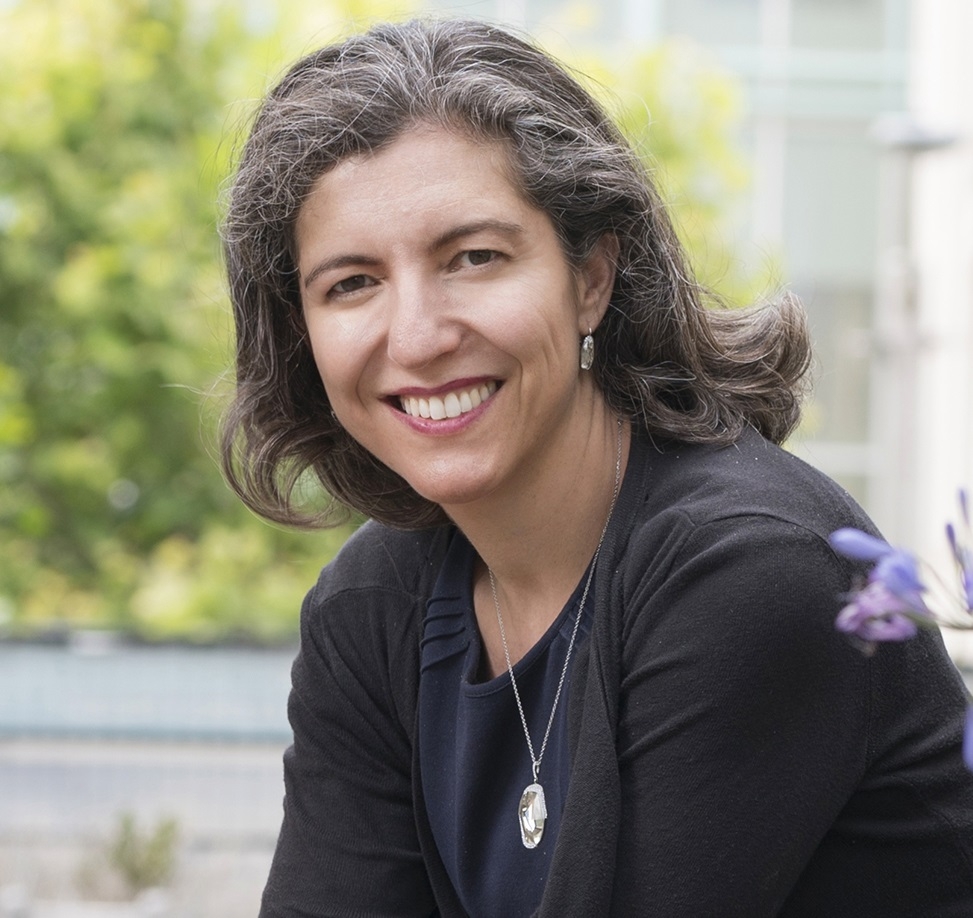 UC Davis Law Professor Chimene Keitner sitting outside wearing a grey top and smiling at the camera.