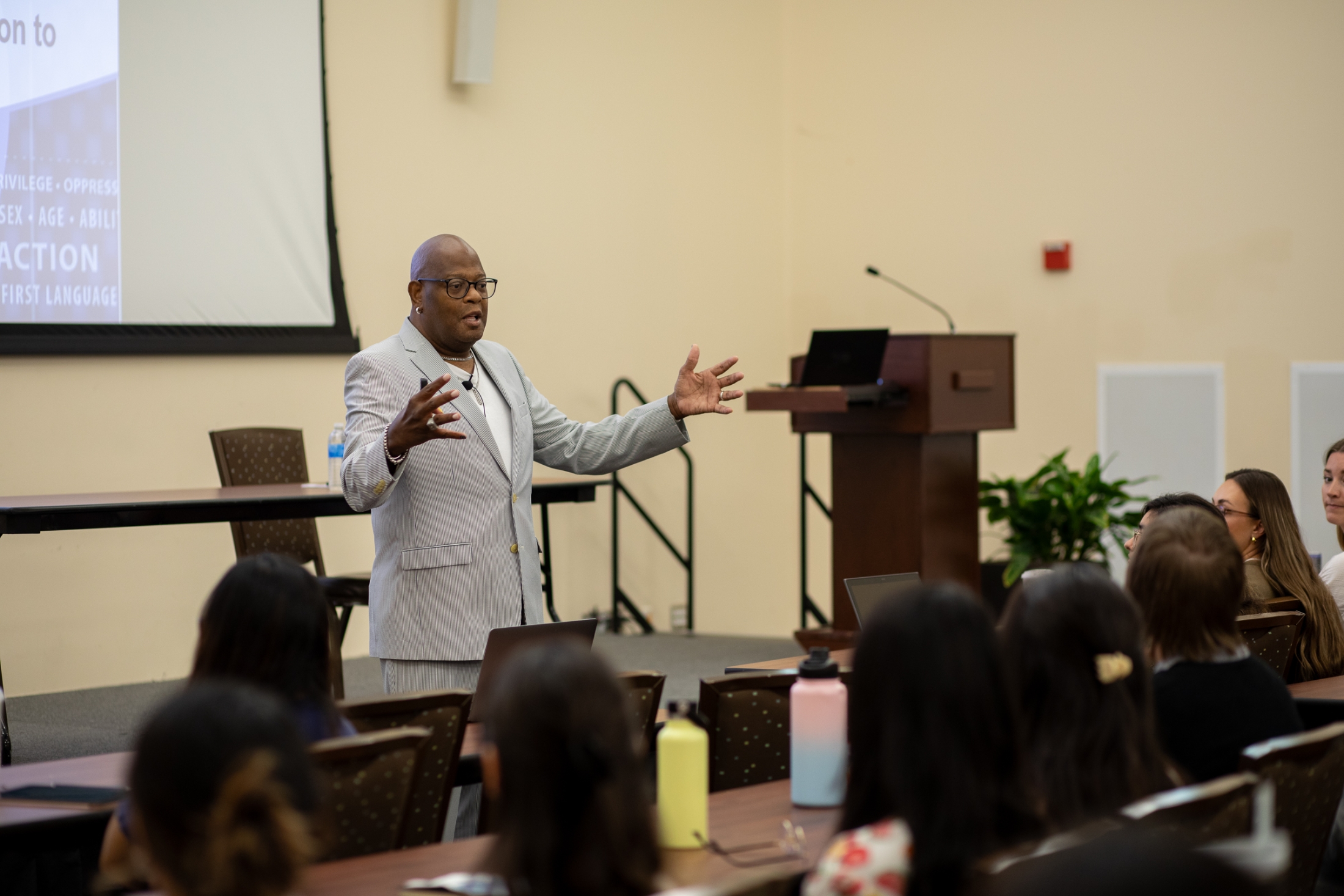 A man addresses a group of students. 