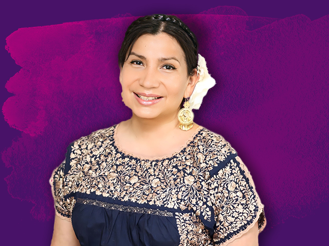 A woman posing in front of a purple background.