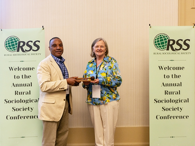 Professor Lisa Pruitt receiving a gavel for her term as president of the Rural Sociological Society (RSS), a professional organization dedicated to promoting knowledge about rural people and places and aiming to elevate the quality of life in rural communities.
