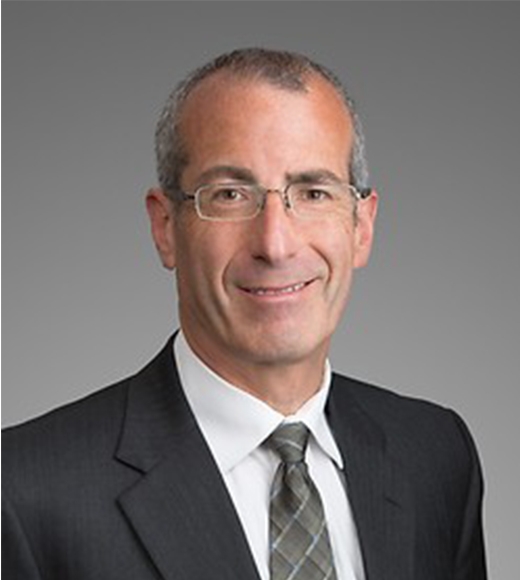 Ted Cohen wearing a gray suit and smiling at the camera.