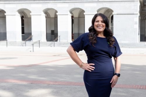 Assemblywoman Esmeralda Soria ’11 wearing a blue dress and smiling outside the Capitol.