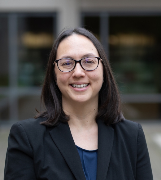 Alyssa Thurston, UC Davis Library Director and Lecturer in Law, wearing glasses and a suit, while smiling.
