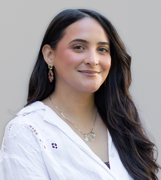 Angelita Mora, International's Admissions and Recruitment Specialist smiling at the camera in front of a white wall.