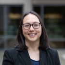 Alyssa Thurston, UC Davis Library Director and Lecturer in Law, wearing glasses and a suit, while smiling.