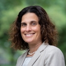 UC Davis Law Dean Berg wearing a grey suit and smiling at the camera.