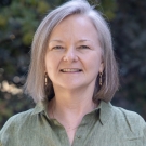 Professor Lisa R. Pruitt wearing a green blouse and smiling at the camera.