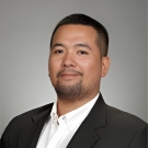 Professional portrait of a man in a suit with a neutral background.
